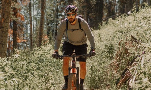 man riding a bike on a trail in the woods